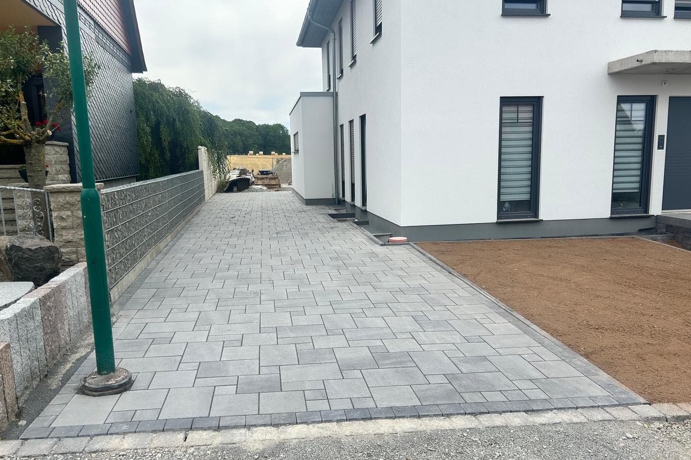 Frisch gepflasterte Zufahrt vor einem Neubau